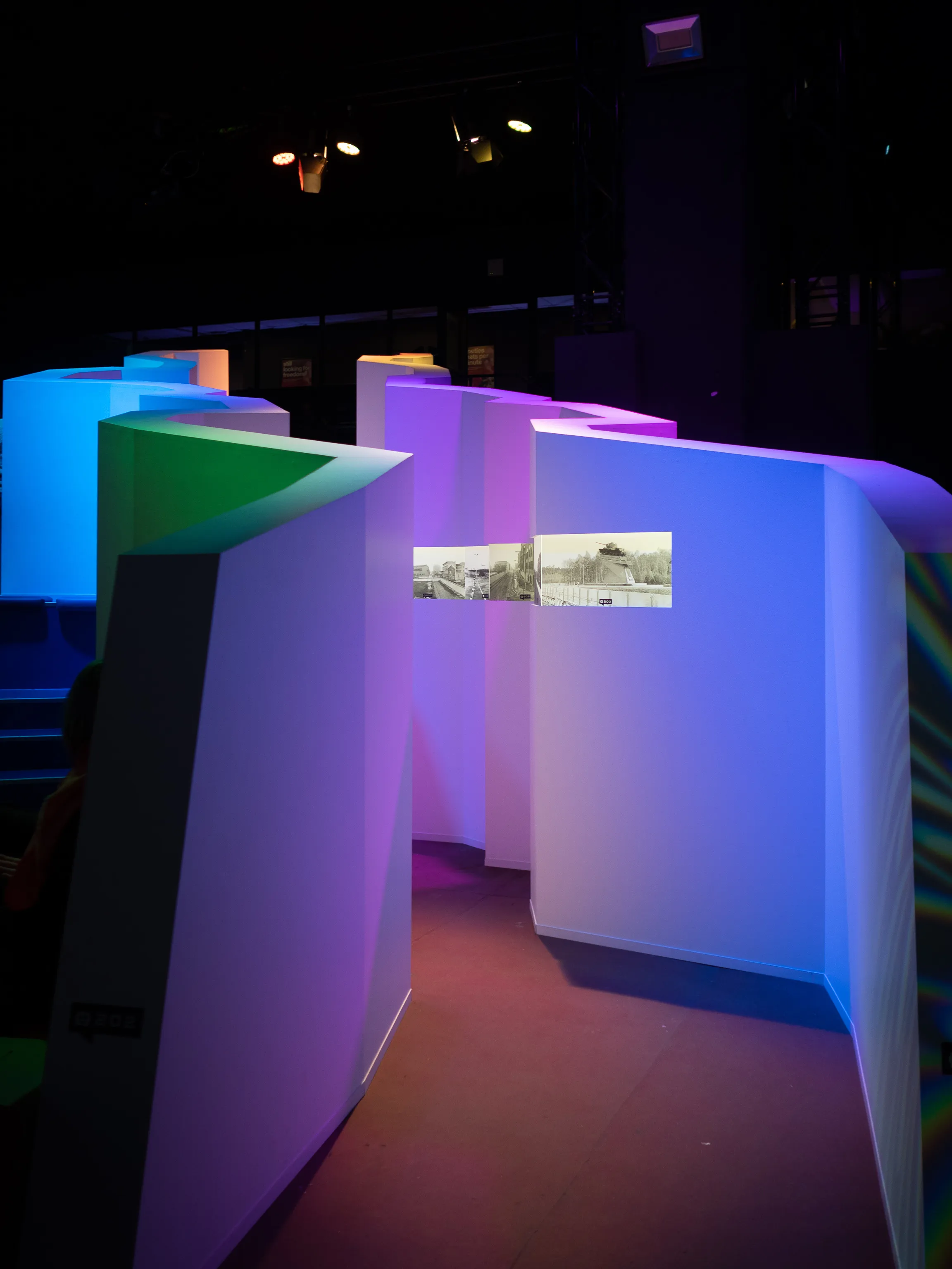A colorful illuminated maze installation fills the event space.