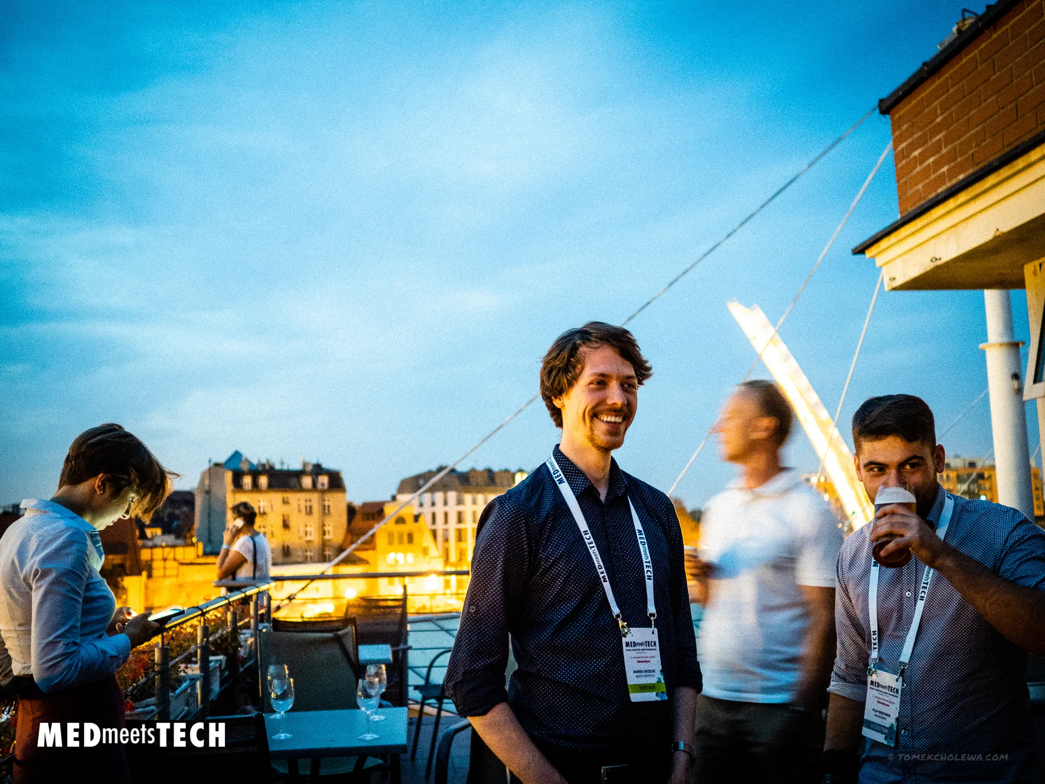 Guests network on a rooftop at dusk during Med Meets Tech.