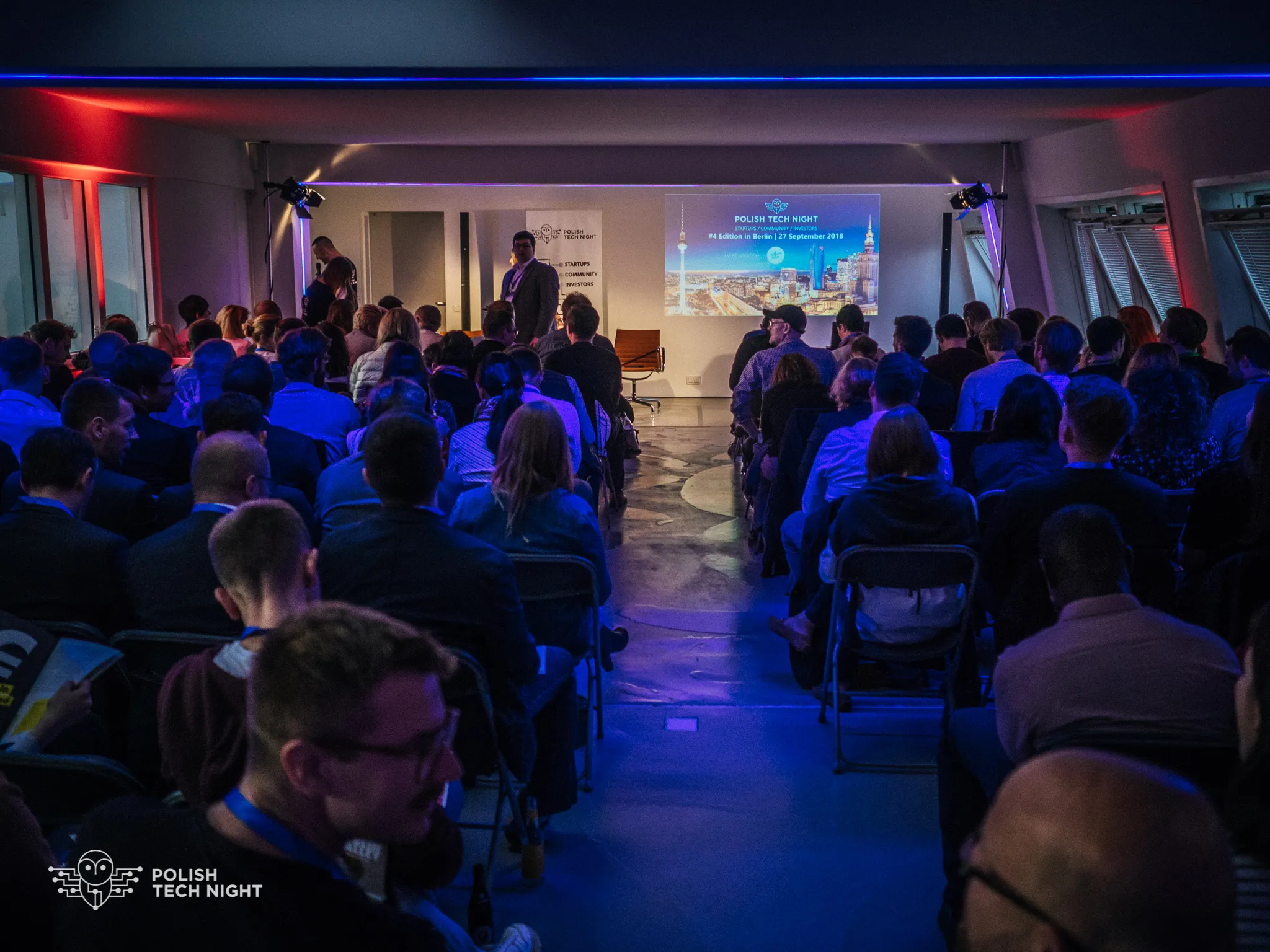 A full audience faces the Polish Tech Night fourth-edition presentation screen.