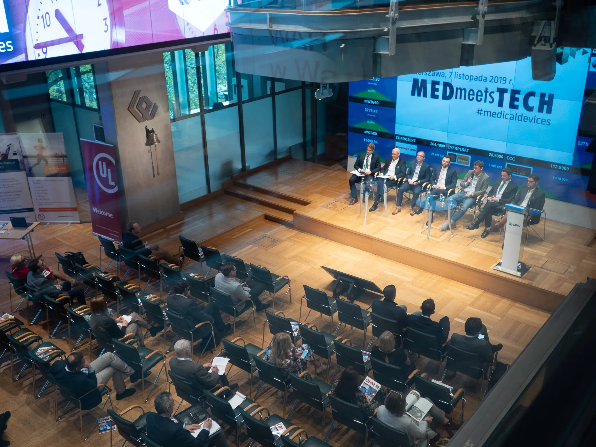 Panel discussion in the Warsaw Stock Exchange hall viewed from above.