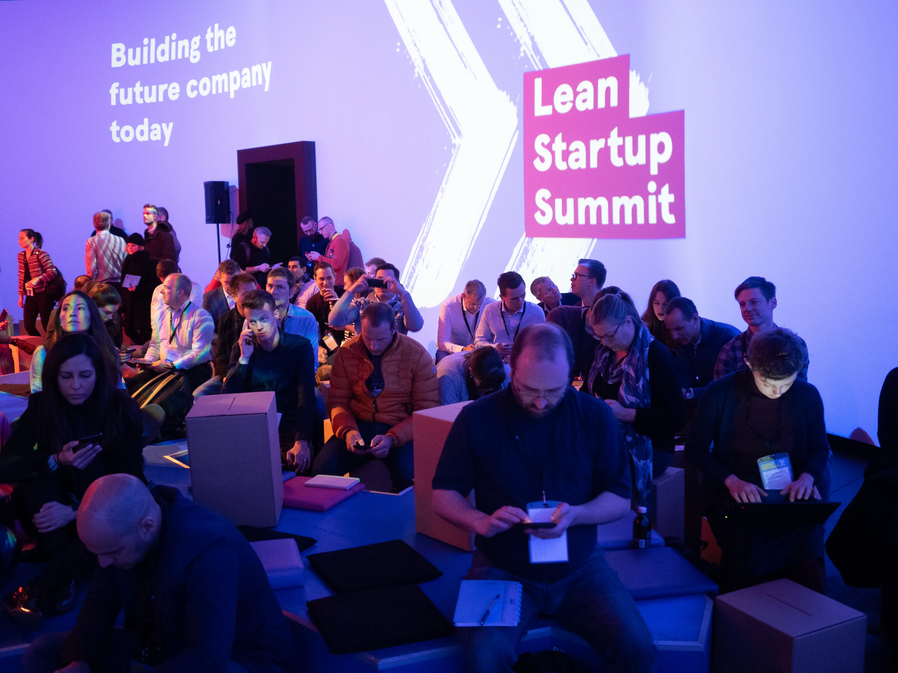Attendees sit on stepped benches beneath Lean Startup Summit branding.